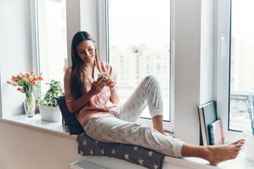 nő pizsamában ül